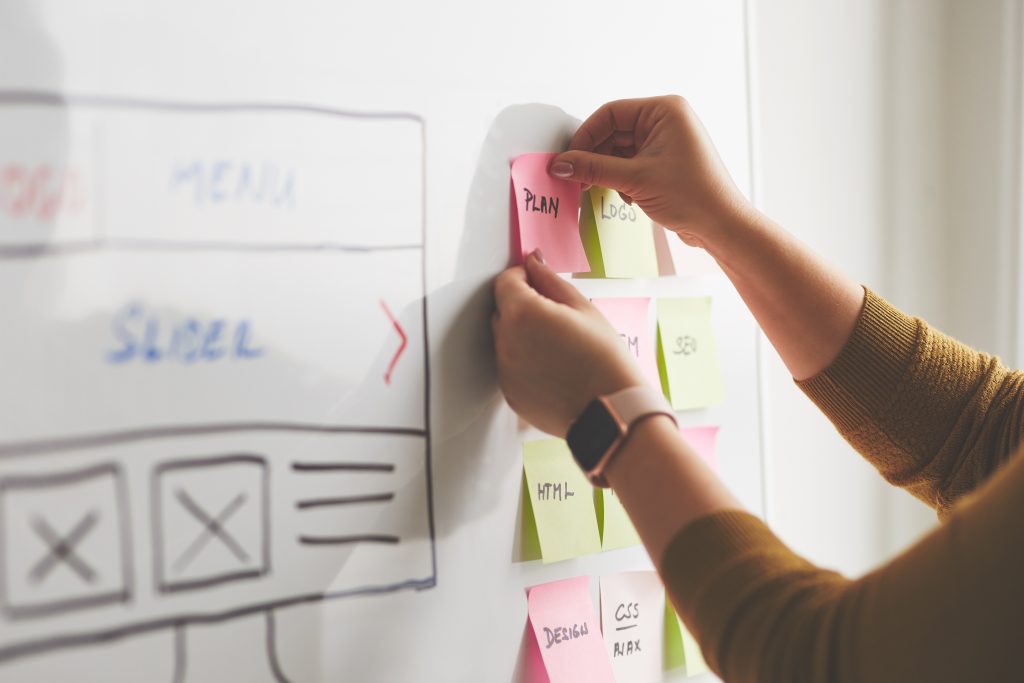 Female web designer planning website ux app development on whiteboard